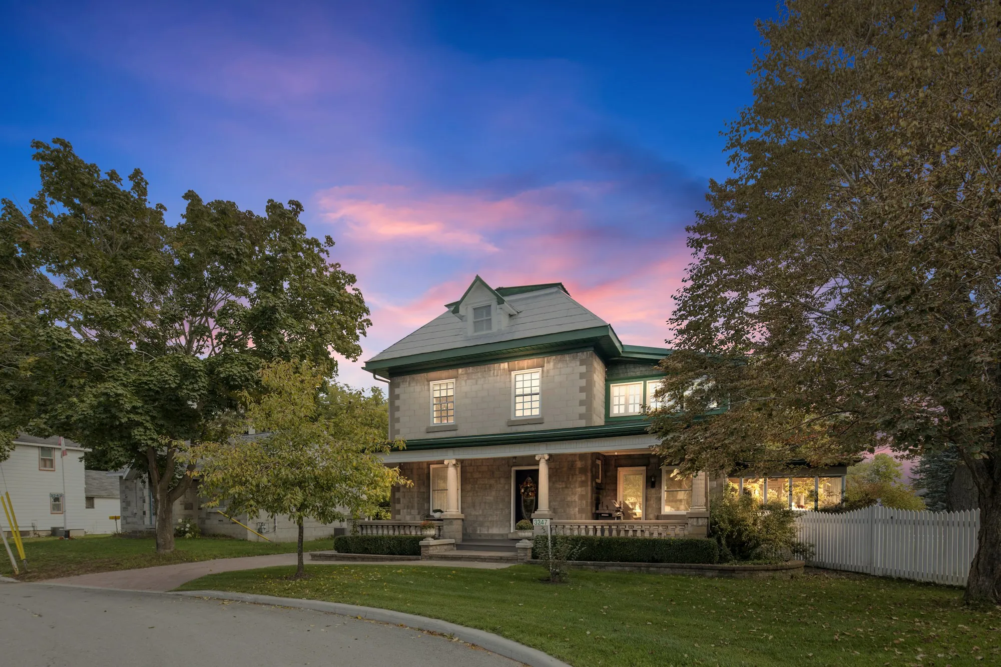Two-story home with a steep shingle roof at twilight